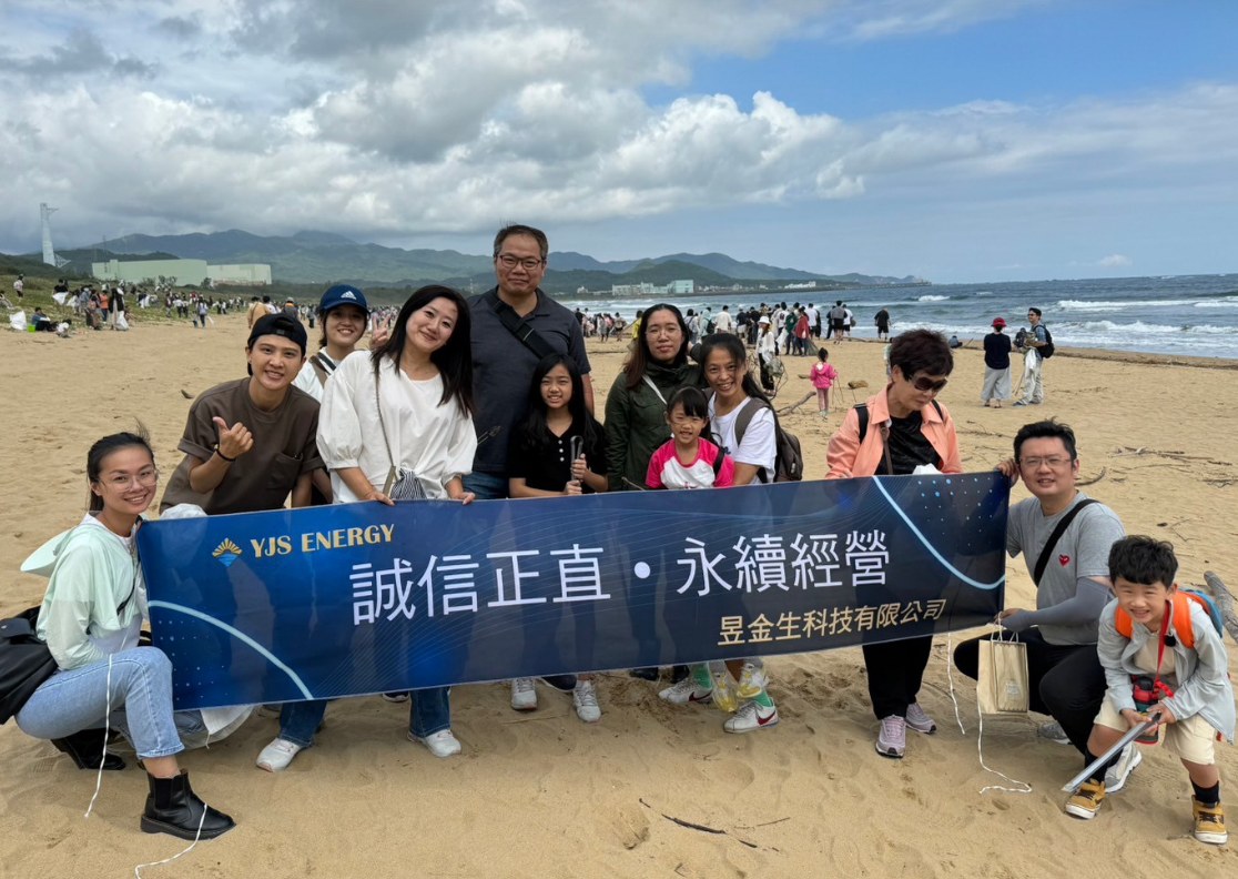 2023 年福隆淨灘活動，參與者在沙灘上拉起昱金生藍色布條合影。